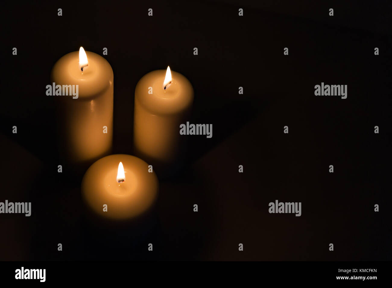 Candles burning burning brightly in the black background Stock Photo