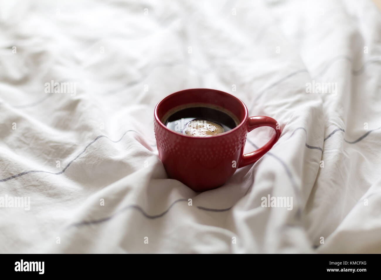 Coffee in red cup served in bed Stock Photo