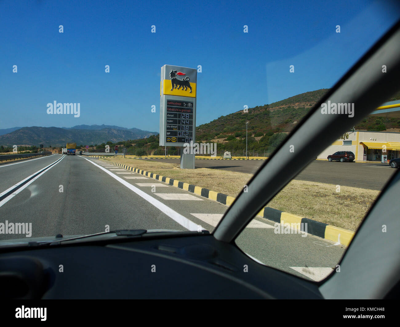 Gas station along an empty road, seen though a windshield, South