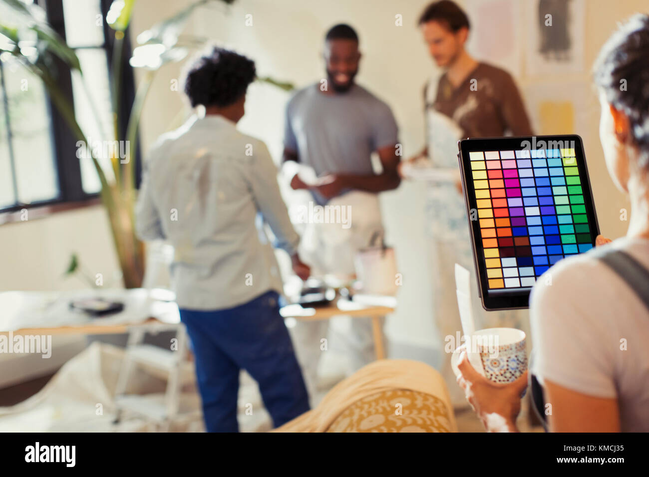 Young woman with digital tablet viewing digital paint colors, painting