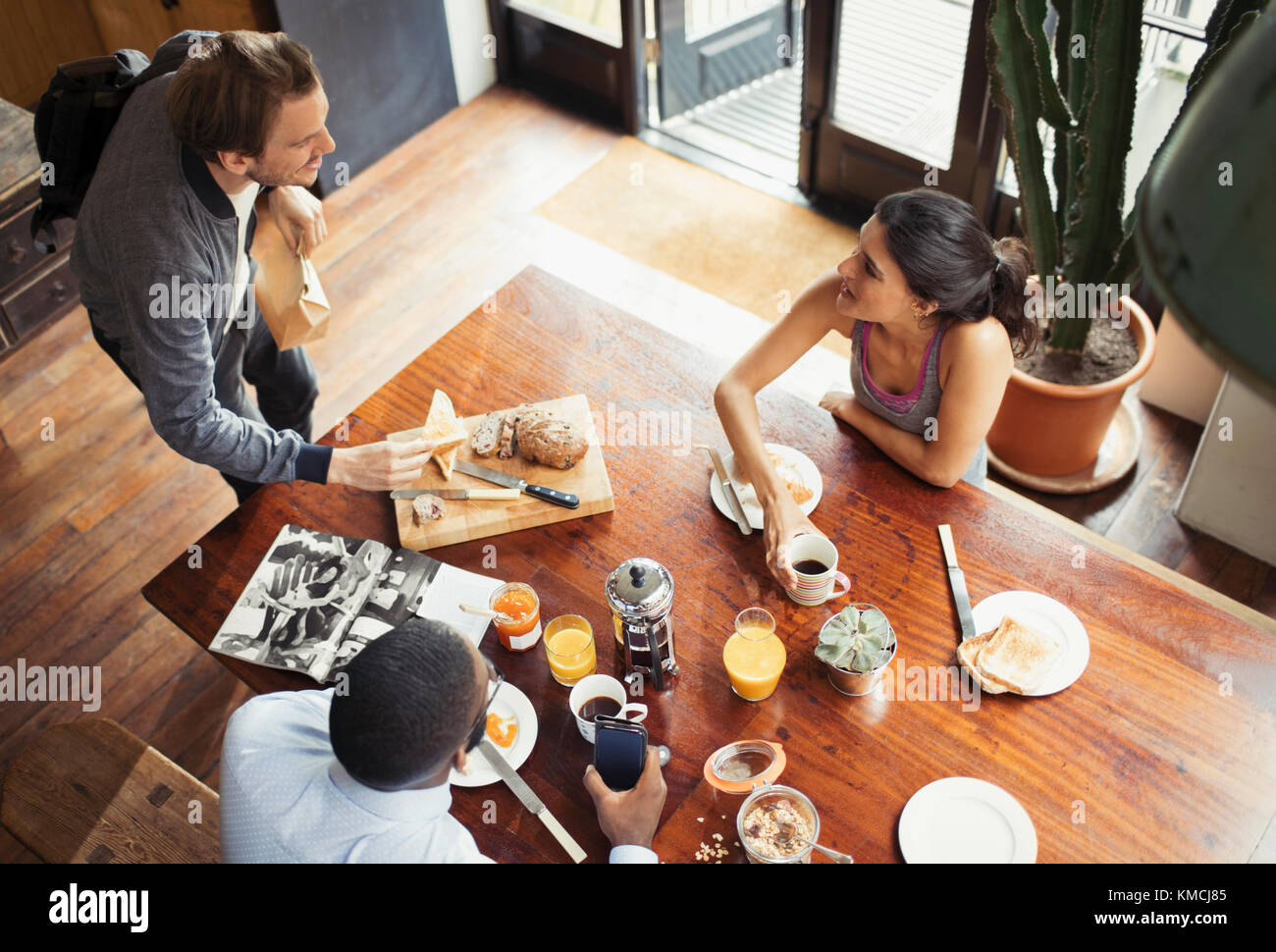 Friend roommates and eating breakfast and drinking coffee at table Stock Photo