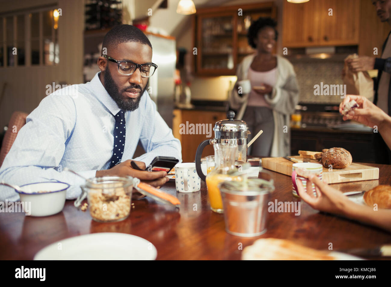 Businessman texting with smart phone at breakfast table Stock Photo