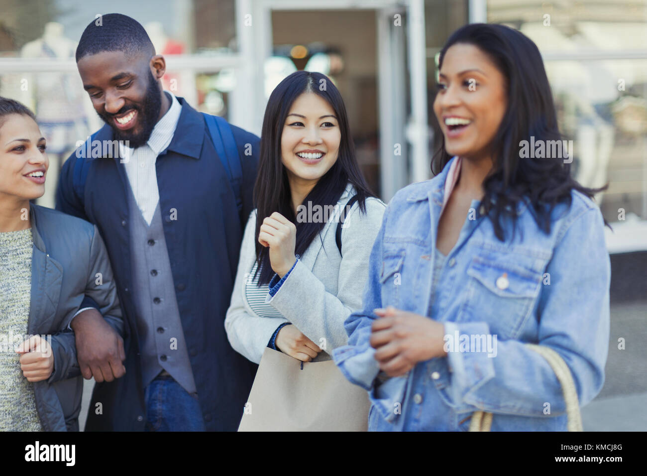 Young friends laughing at storefront Stock Photo