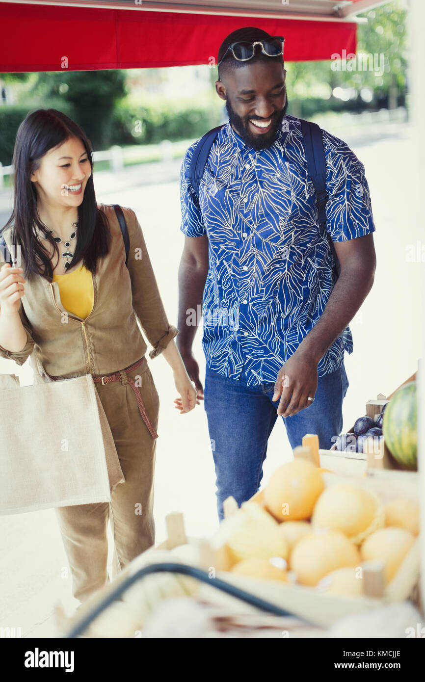 Young couple shopping for produce at market storefront Stock Photo