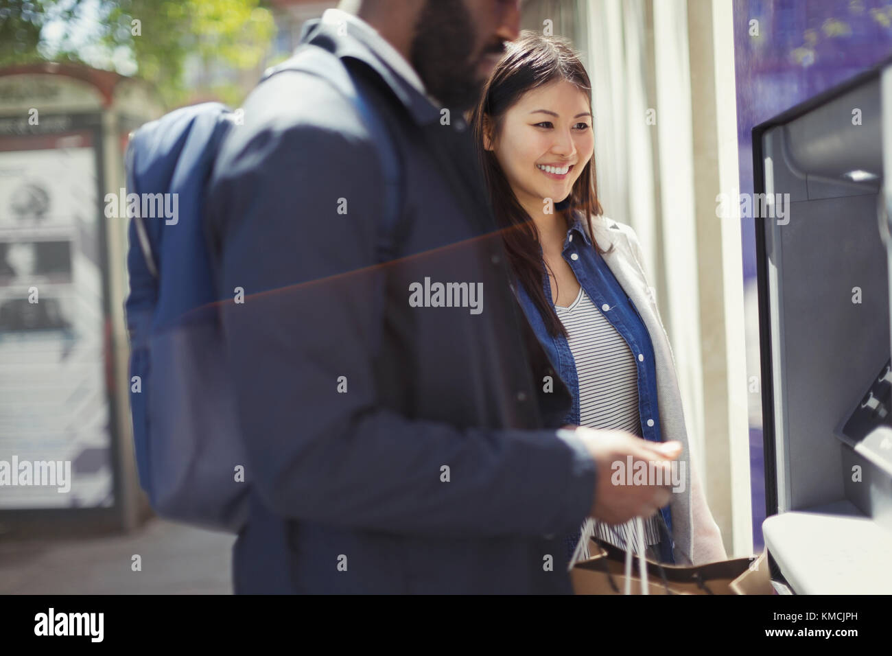 Young couple using ATM Stock Photo