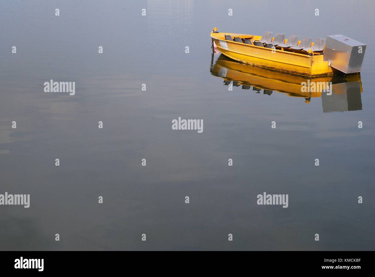 Small yellow boat floating in a large body of water Stock Photo - Alamy