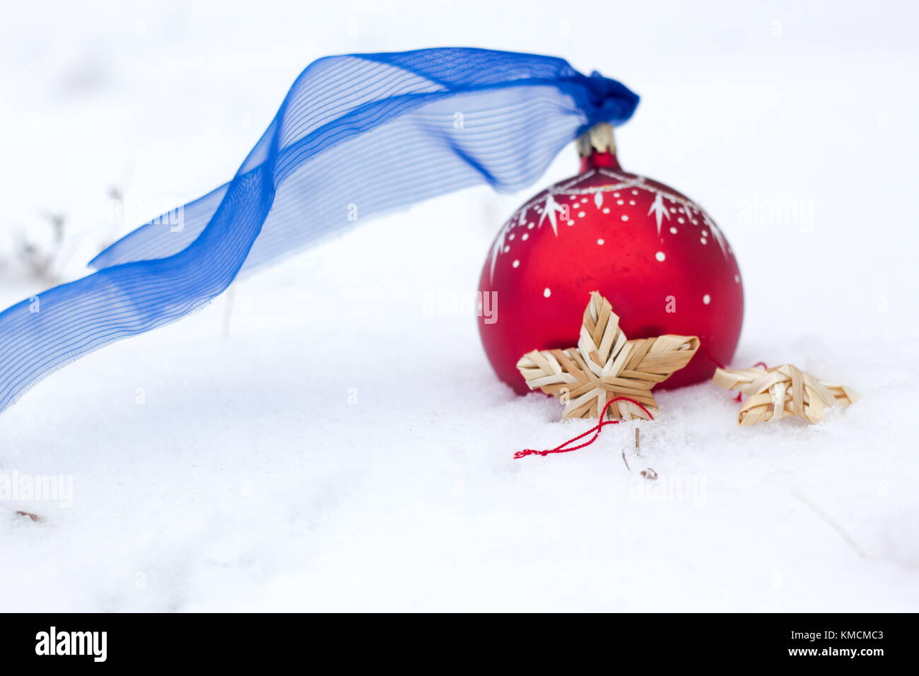 Red christmas toy: red Ball and wattle straw star and angel decor on snow. Winter holiday background Stock Photo