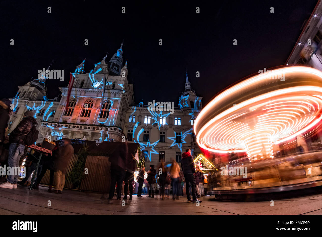 Spinning carousel on christmas fair on main square in Graz with town hall Stock Photo