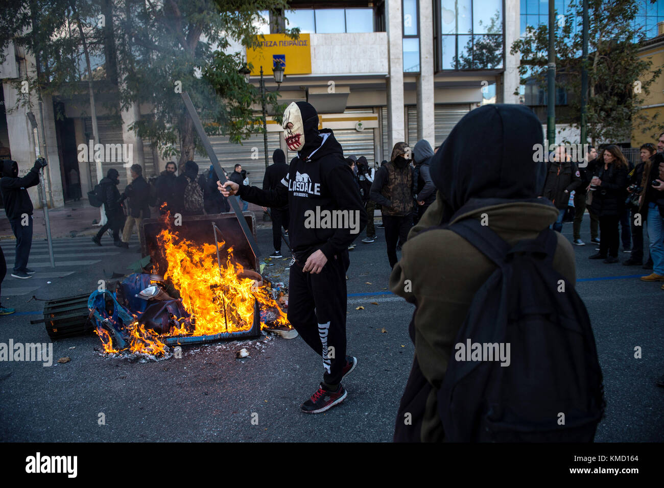 Athens, Greece. 6th Dec, 2017. Masked people can be seen partaking in a protest match in Athens, Greece, 6 December 2017. The ninth anniversary of the death of a 15 year old by police bullet was marked by riots. Some 200 masked persons threw stones against the police, devastated shops and cafés and lit some trash containers on fire. Credit: Angelos Tzortzinis/dpa/Alamy Live News Stock Photo