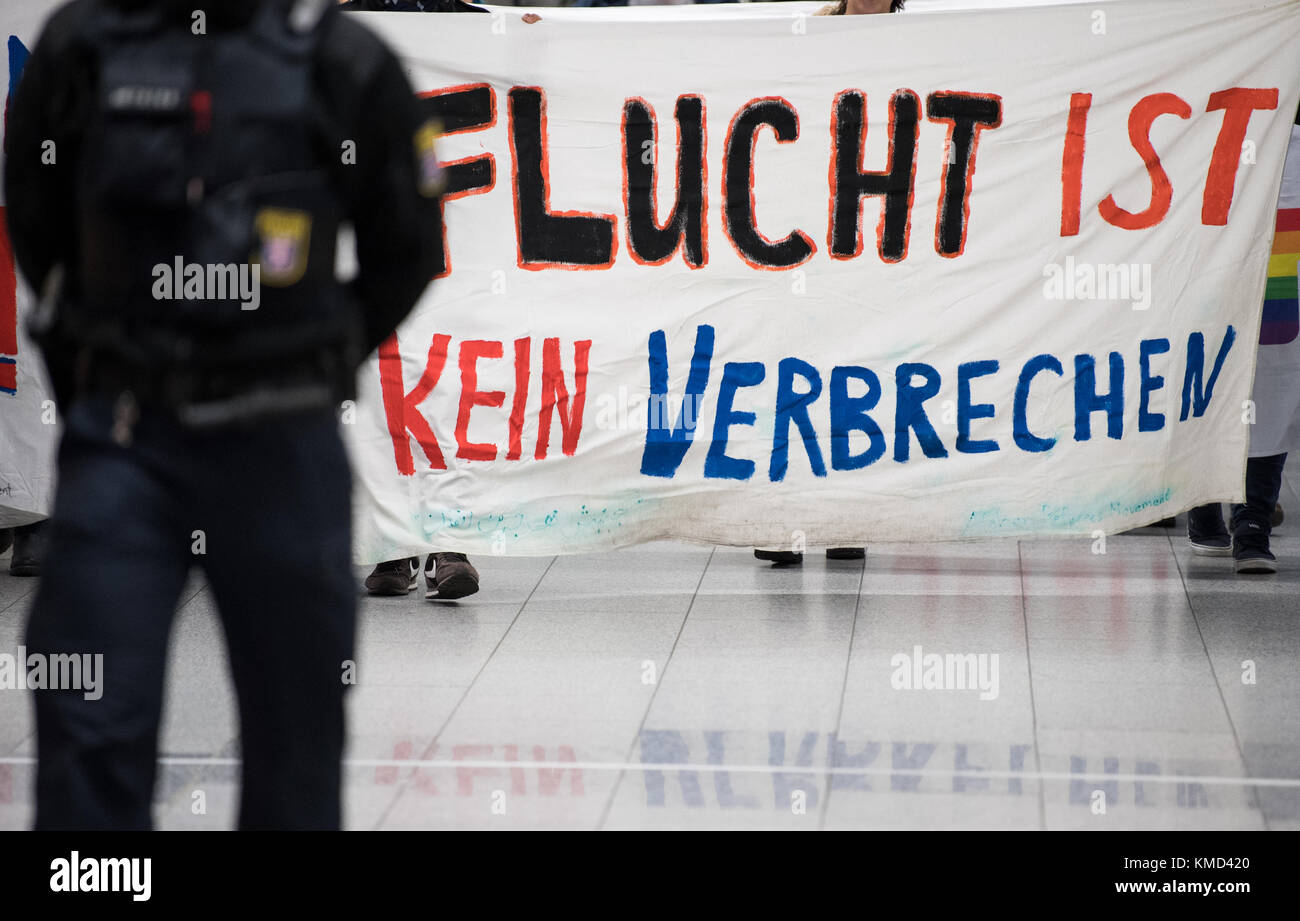 Frankfurt am Main Airport, Germany. 06th Dec, 2017. A police officer watches a demonstration against a planned deportation flight to Afghanistan at Terminal 1 of Frankfurt am Main Airport, Germany, 06 December 2017. The banner reads 'Flucht ist kein Verbrechen' (lit. flight is no crime). Credit: Fabian Sommer/dpa/Alamy Live News Stock Photo