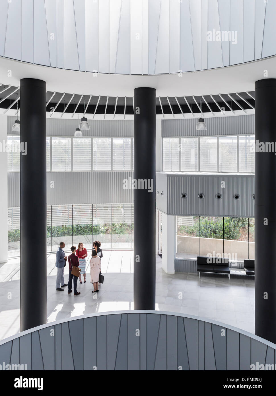 Business people talking in modern office atrium Stock Photo