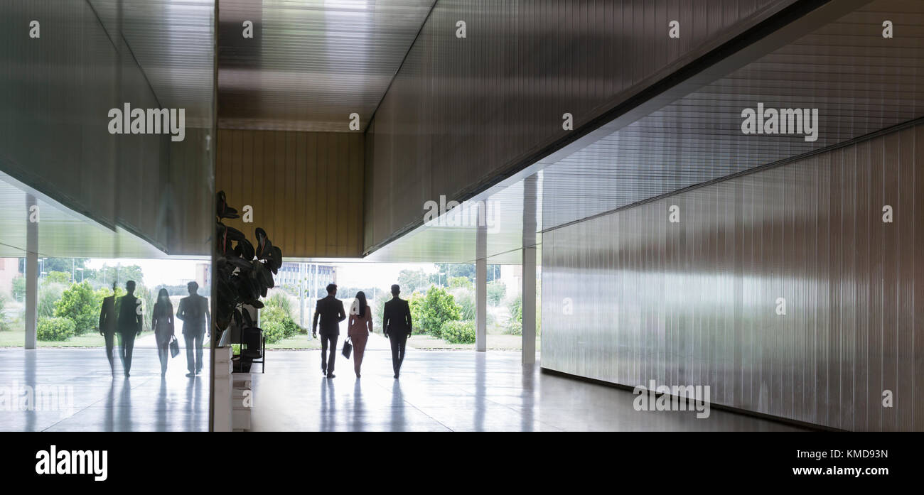 Silhouette business people walking in modern corridor Stock Photo