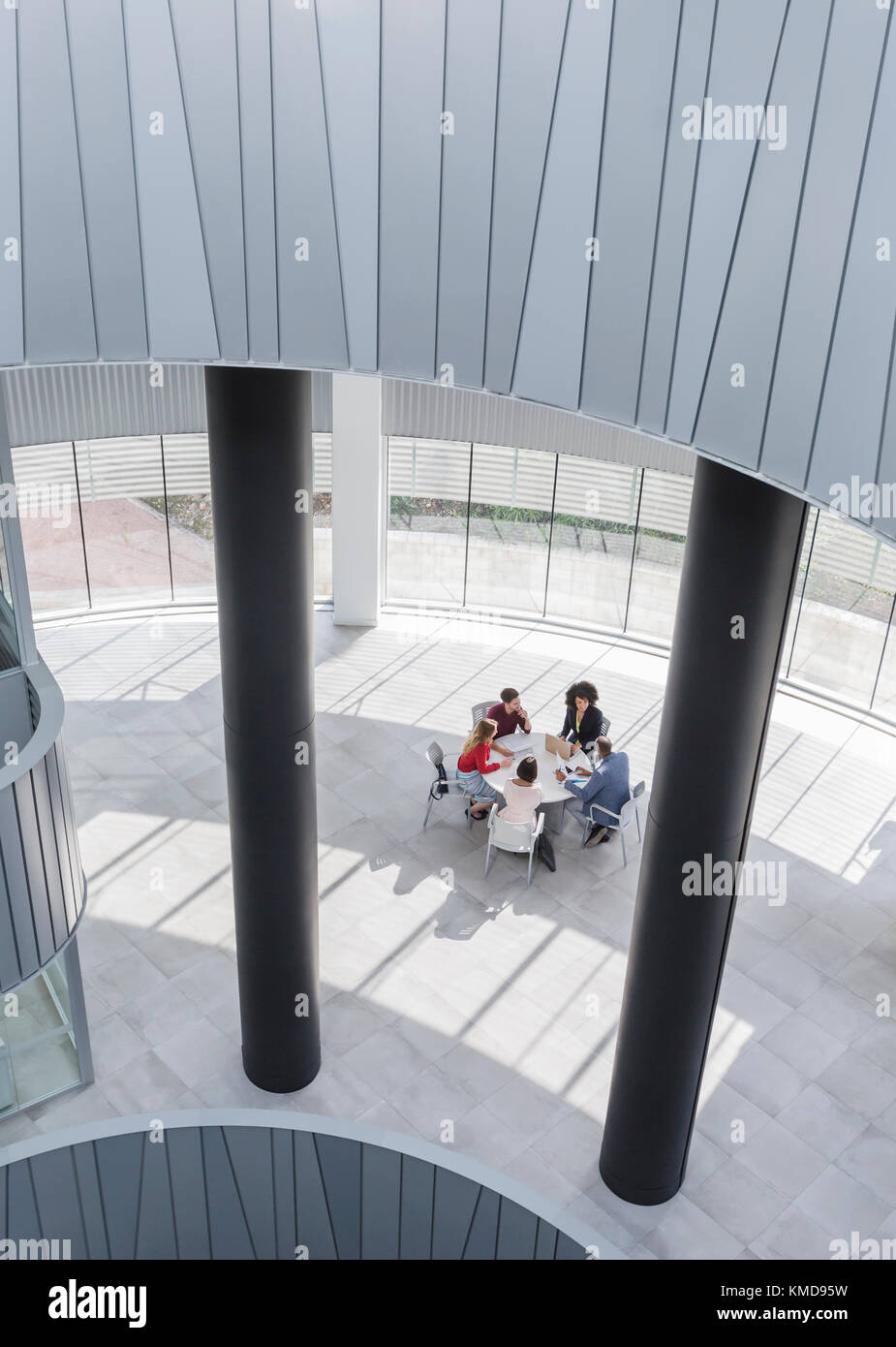 Business people meeting at table in modern office atrium Stock Photo