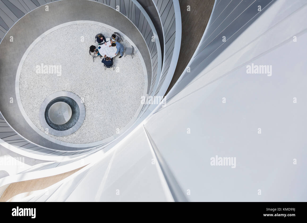 View from above business people meeting at table in round office atrium courtyard Stock Photo