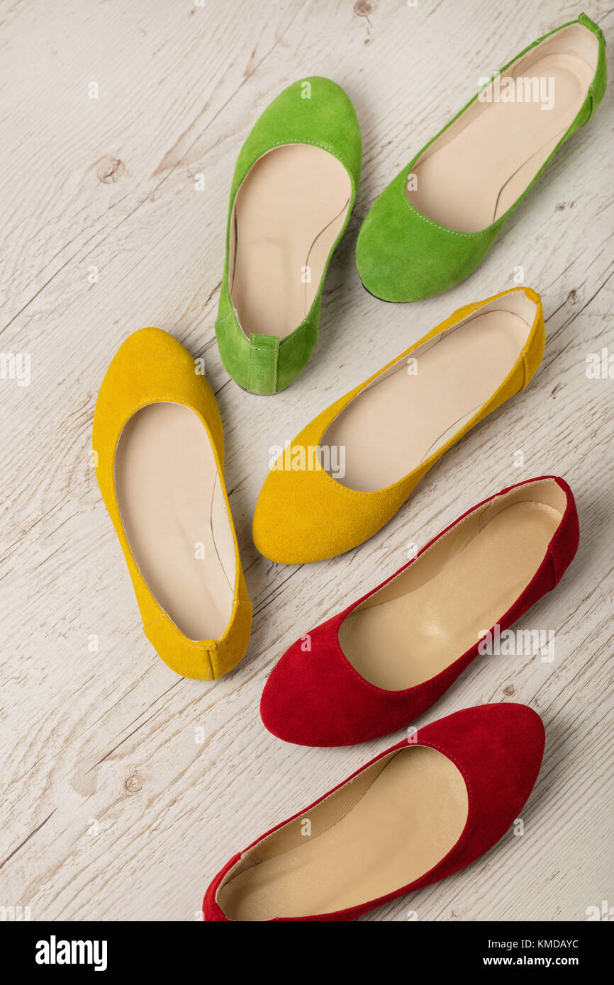 Colorful shoes (ballerinas) on a white wooden background. Selective ...