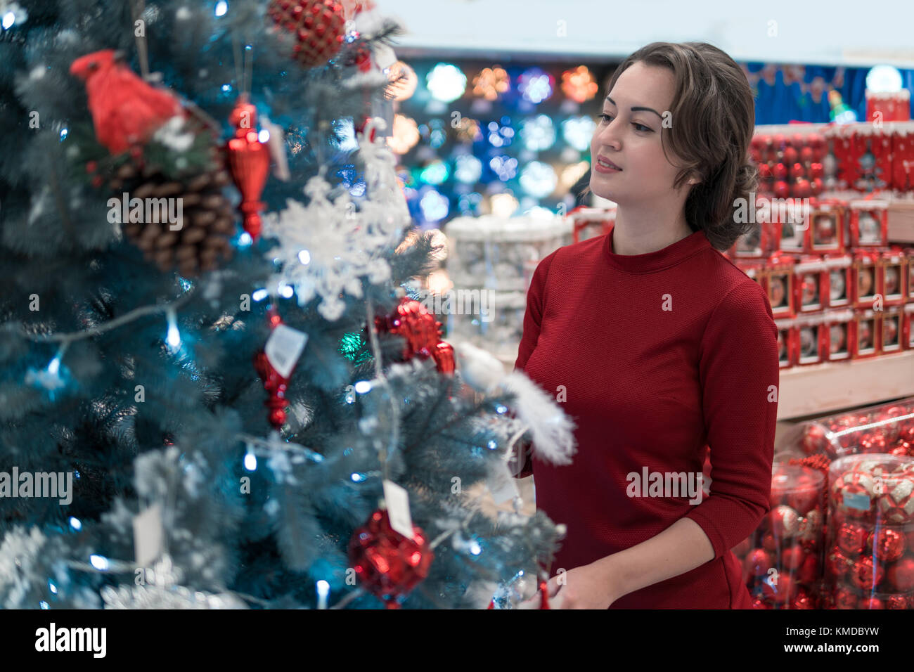 happy customer girl choosing Christmas tree for the new year Stock Photo