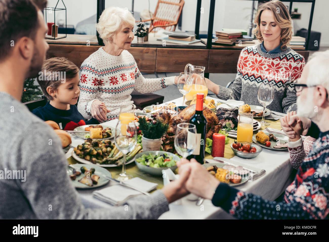 family praying at christmas table Stock Photo