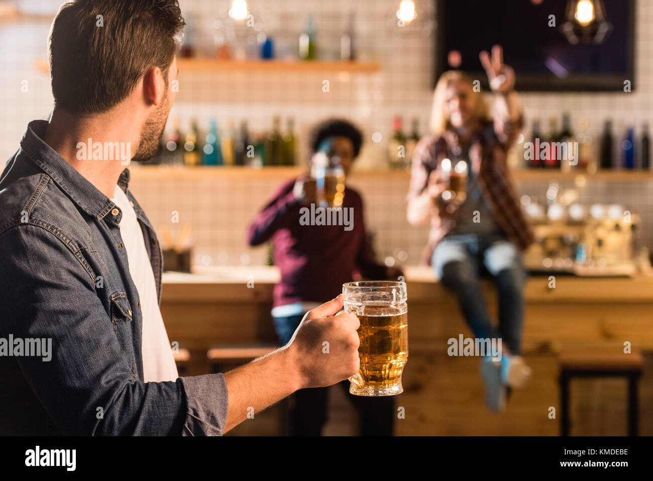 man with beer looking at friends Stock Photo Alamy