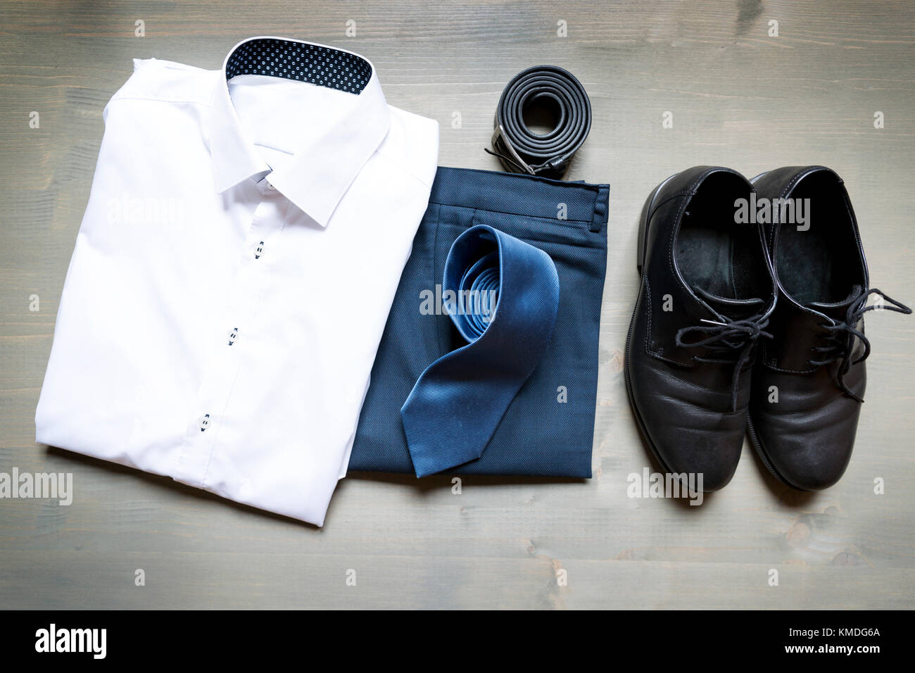 Folded businessman's clothes and shoes. White shirt, blue pants ...