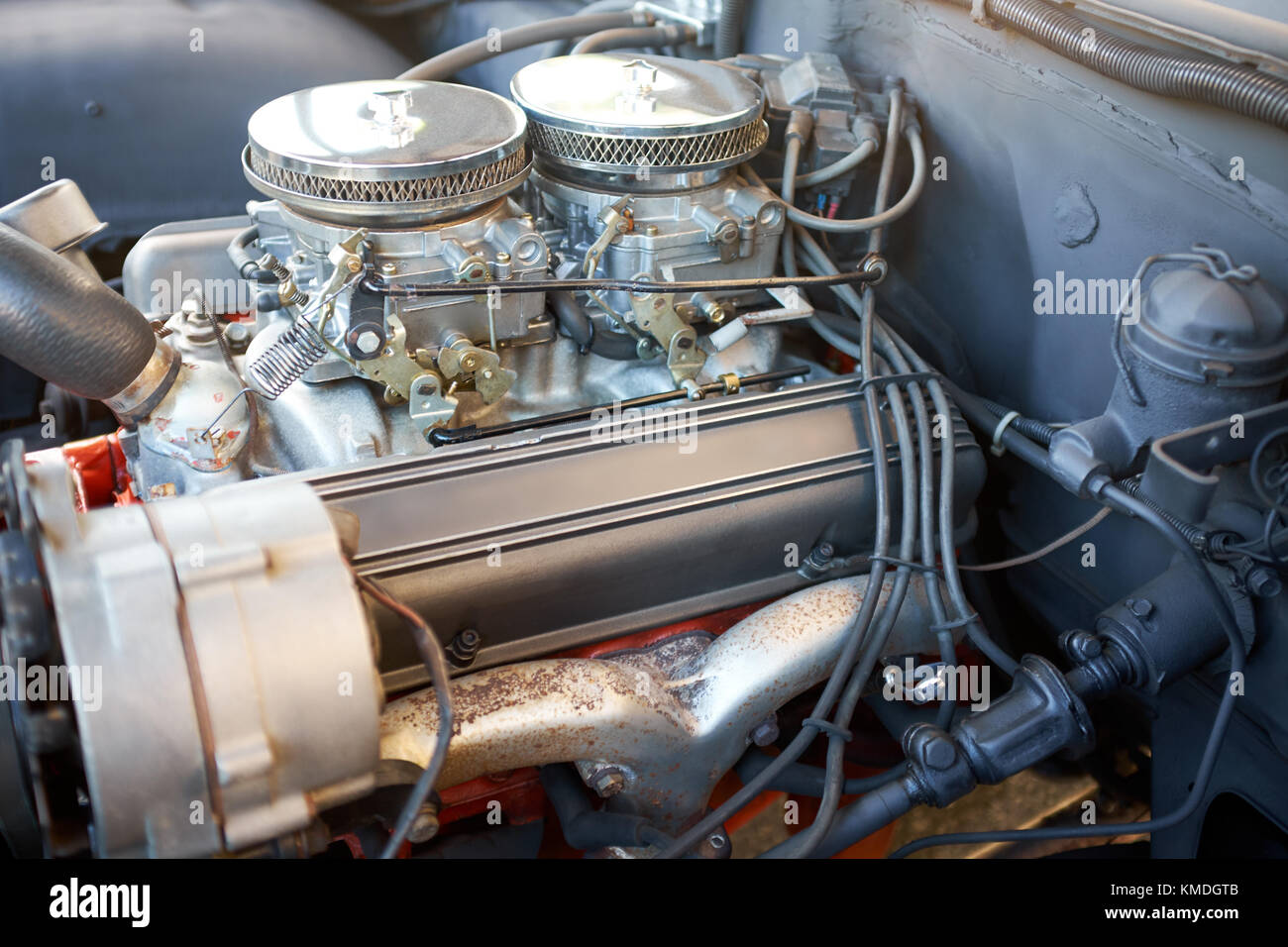 Old car engine after repair, with some parts replaced and painted, closeup under the hood from