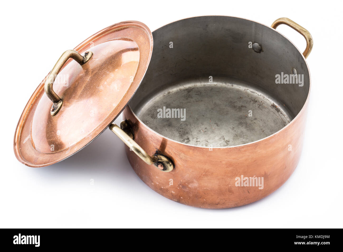 Opened copper pan and cover near it. Isolated on white background. Stock Photo