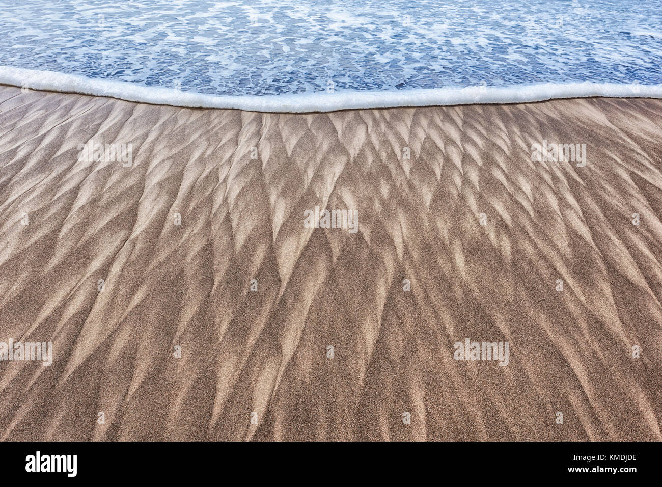 Abstract closeup image of sand patterns left by a retreating wave on the beach at Pacific City on the Oregon Coast Stock Photo