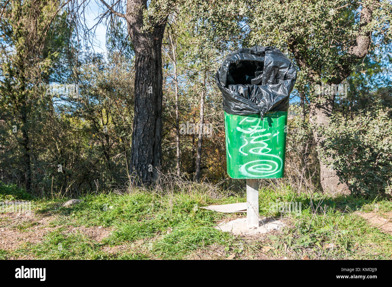green trash with trash bag tied outside Stock Photo