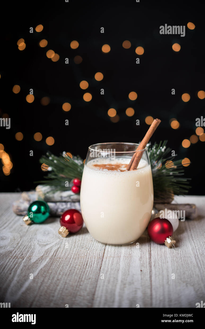 Egg nog in a glass.  Garnished with cinnamon and holiday ornaments Stock Photo