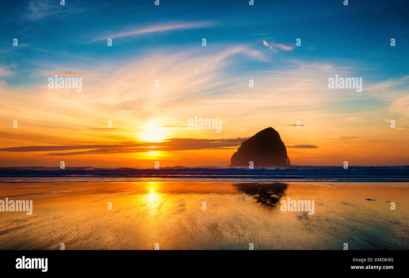 Hay Stack Rock at Pacific City, on the oregon coast, is silhouetted by the setting sun Stock Photo
