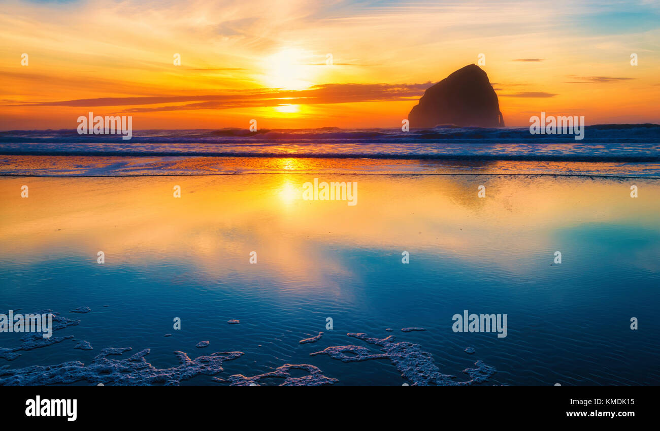 Hay Stack Rock at Pacific City, on the oregon coast, is silhouetted by the setting sun Stock Photo