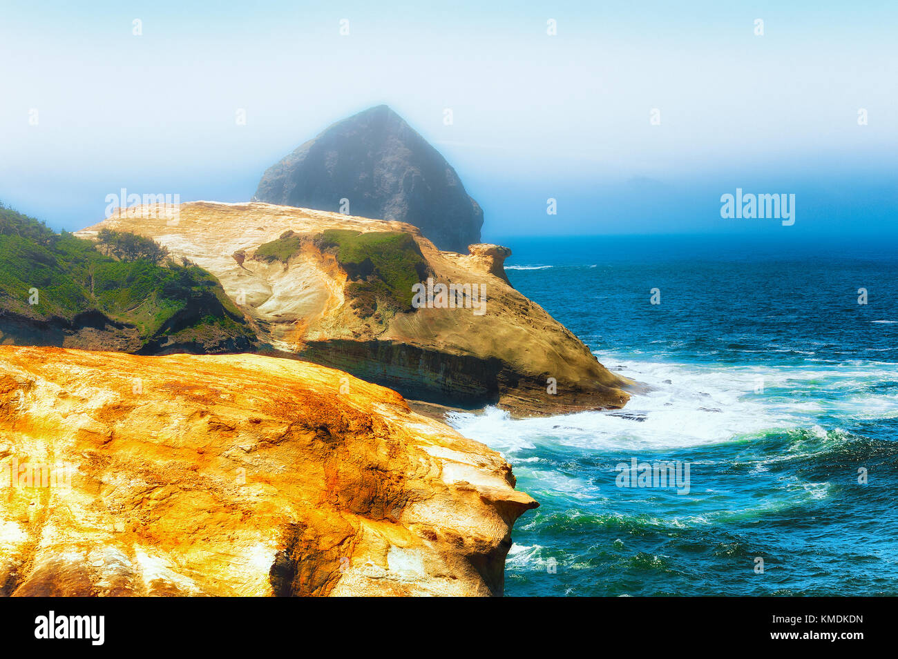 Sandstone cliffs and haystack rock dominate this Pacific shoreline view at Cape Kiwanda in Pacific City on the Oregon Coast. Stock Photo