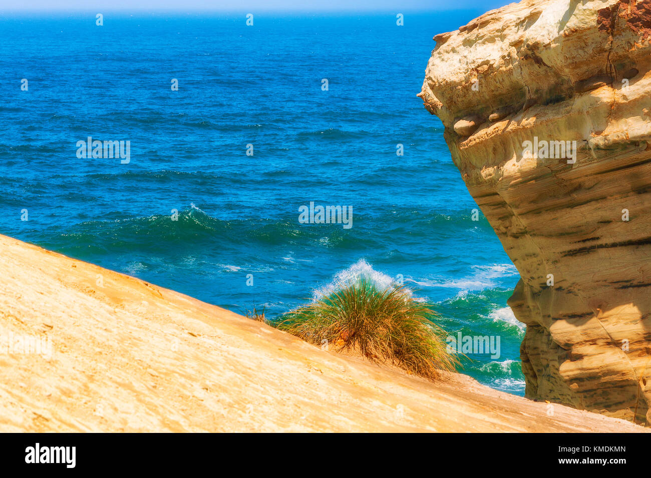 Sandstone stands out against the blue waters of the Pacific Ocean Stock Photo