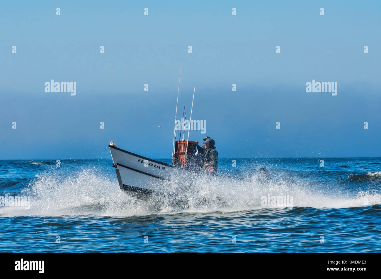Pacific City, Oregon, USA - July 2, 2015: A dory boat passes through the surf as it's captain makes his approach to landing on the beach in Pacific Ci Stock Photo