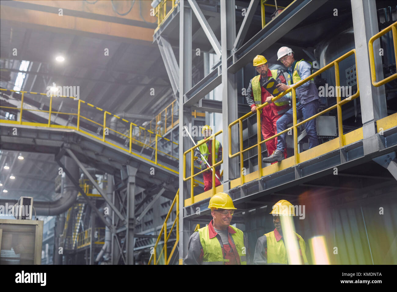 Steelworkers talking on platform in steel mill Stock Photo - Alamy