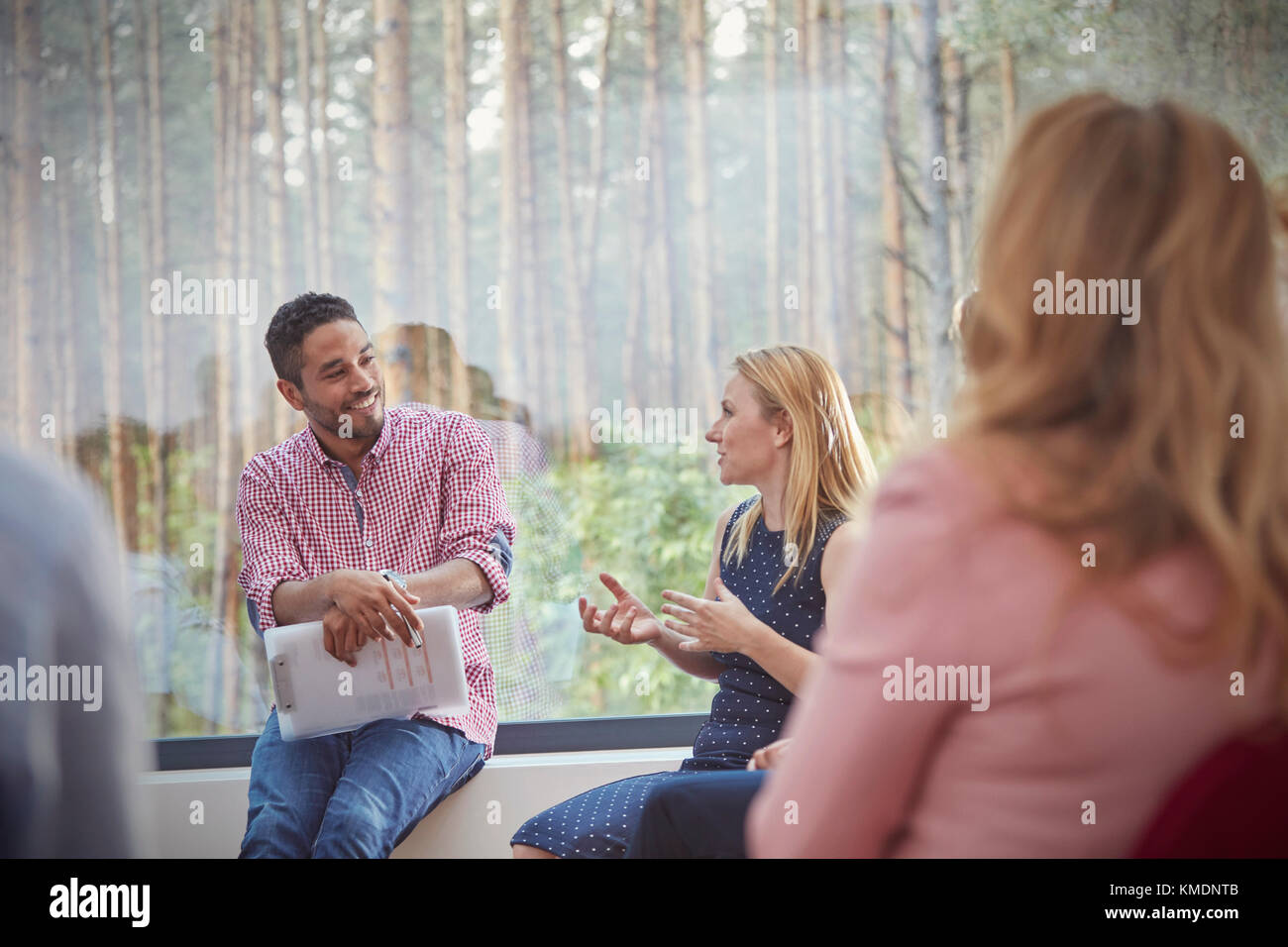 Male therapist listening to talking woman in group therapy session Stock Photo