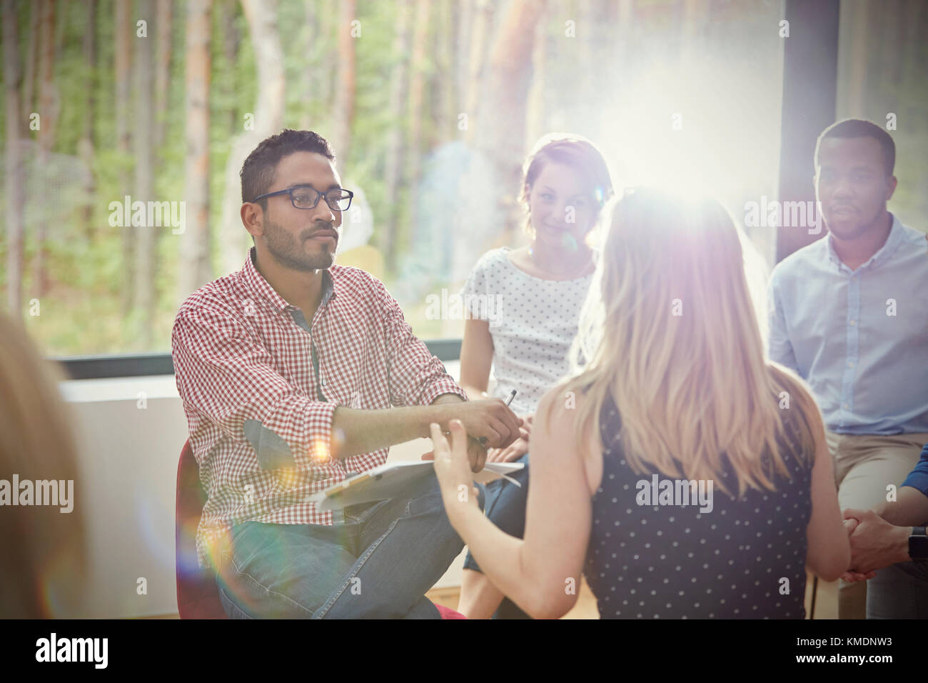 Attentive man listening to woman in group therapy session Stock Photo