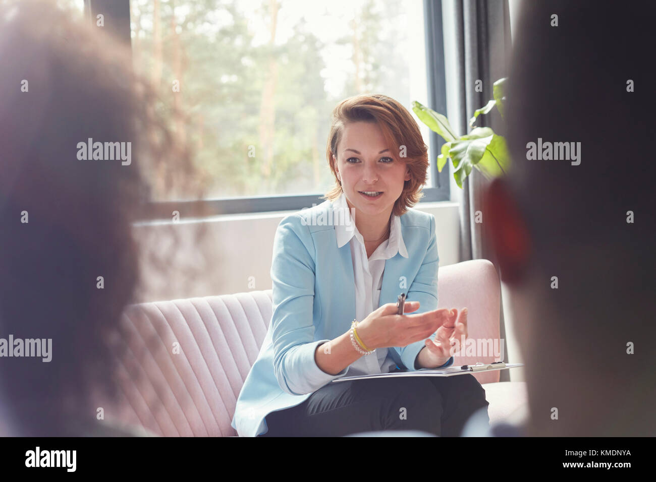 Female therapist talking to couple in couples therapy session Stock Photo