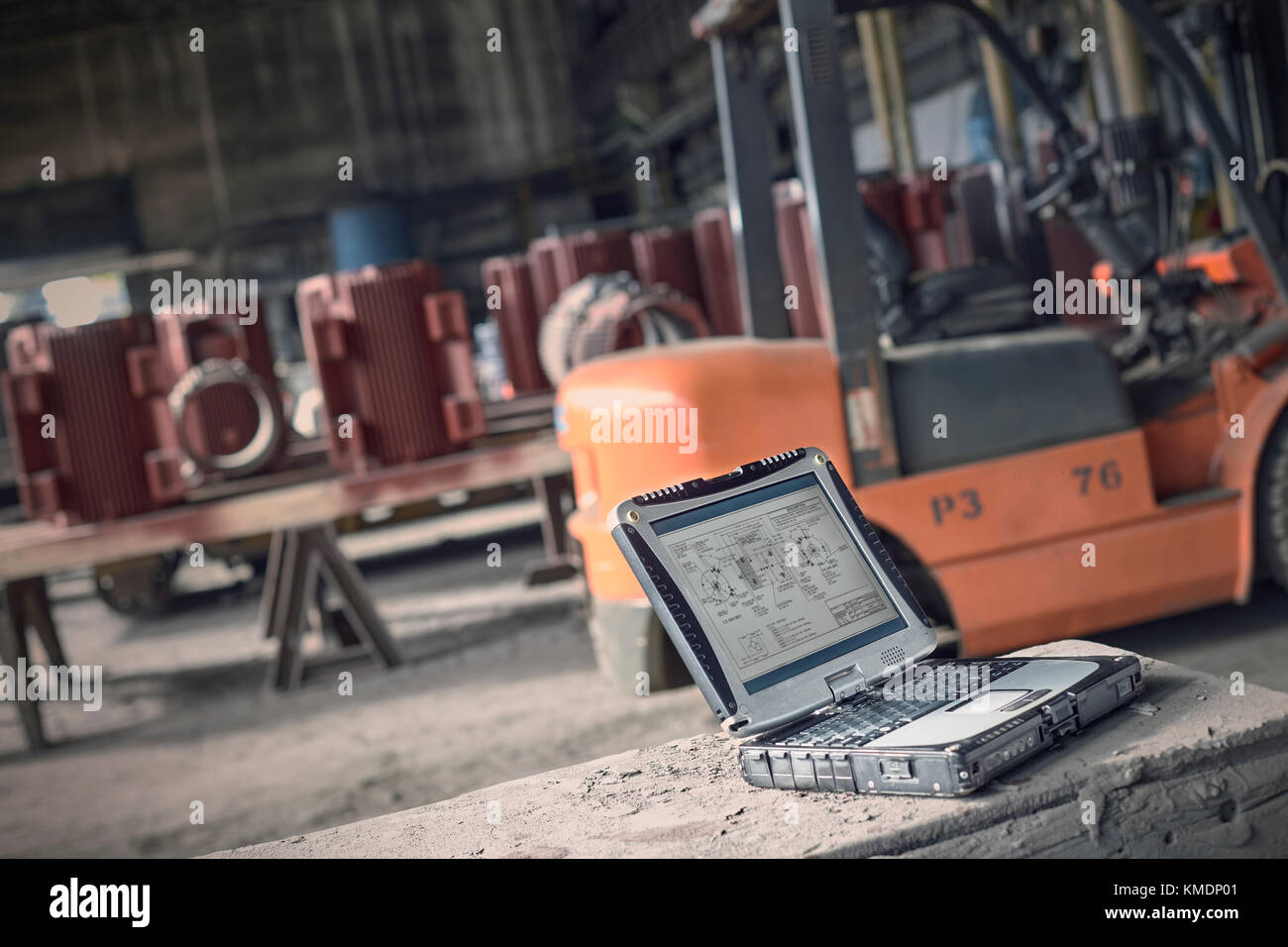Digital blueprints on laptop in steel mill Stock Photo