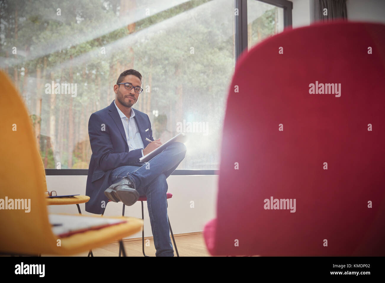 Portrait confident businessman writing on clipboard in office Stock Photo