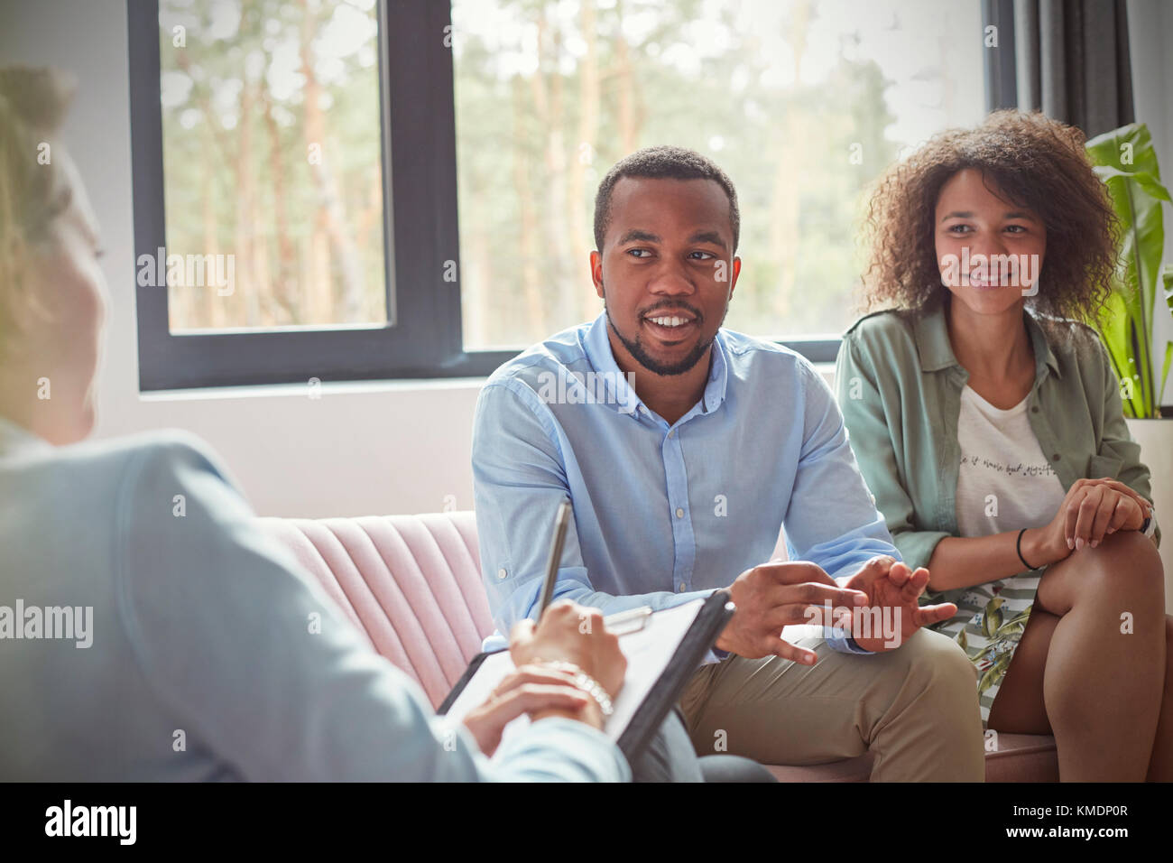 Couple listening to female therapist in couples therapy counseling
