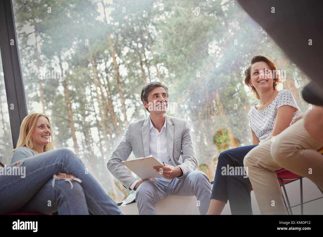 Smiling people talking in group therapy session Stock Photo