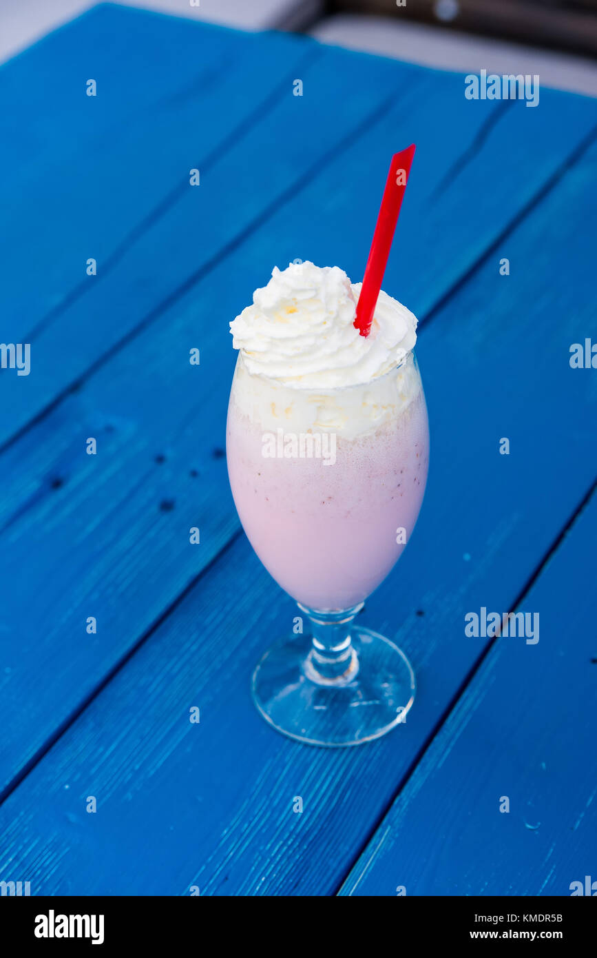 Milkshake with cream and straw in restaurant Stock Photo Alamy