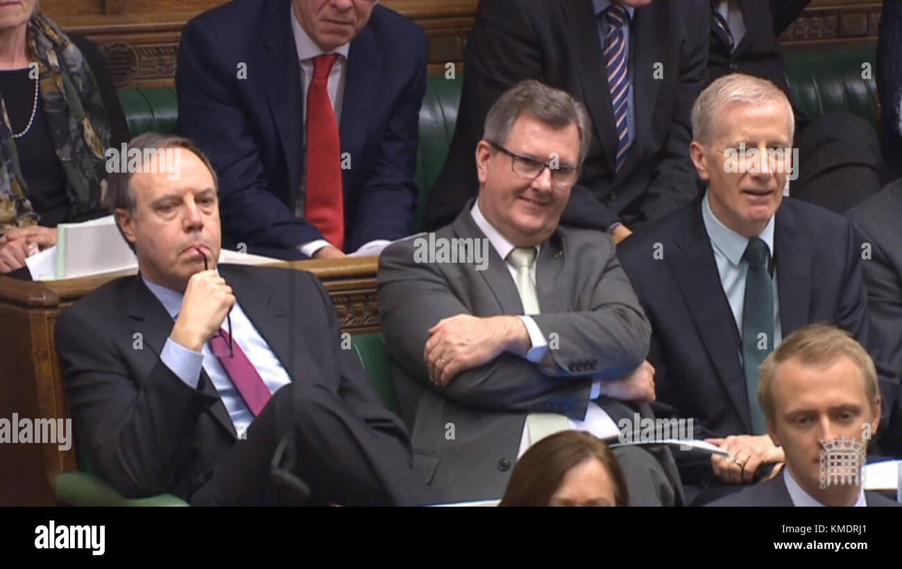 DUP MPs (left to right) Nigel Dodds, Sir Jeffrey Donaldson and Gregory Campbell listen in as Prime Minister Theresa May speaks during Prime Minister's Questions in the House of Commons, London. Stock Photo