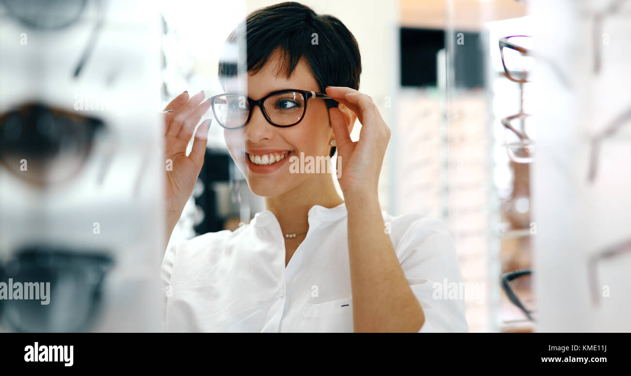Beautiful woman with optician trying eyeglasses Stock Photo