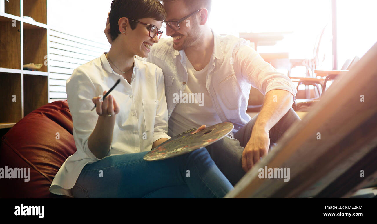 Beautiful young woman and a handsome man attending a painting workshop together Stock Photo