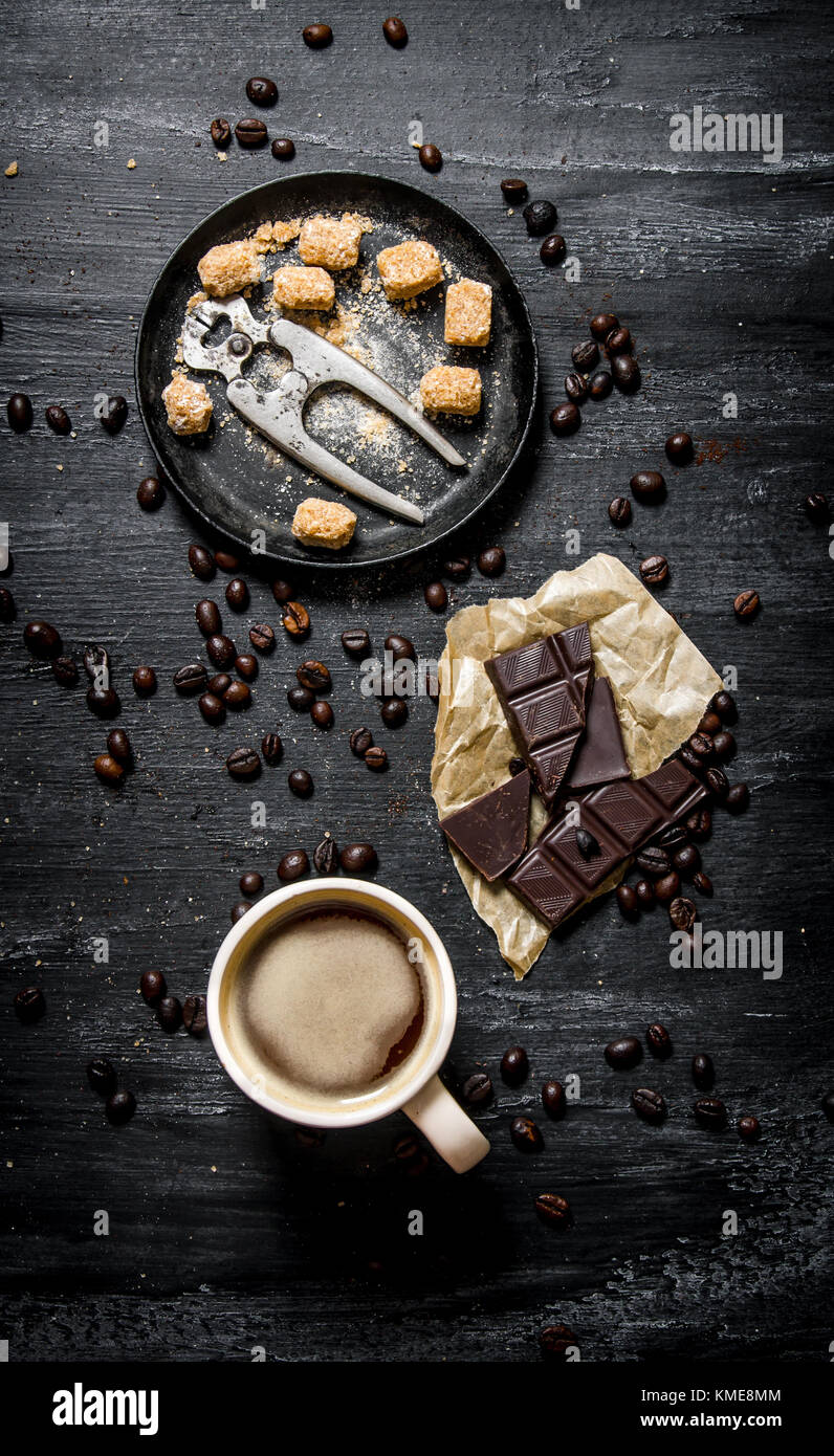 https://c8.alamy.com/comp/KME8MM/a-cup-of-coffee-with-bitter-chocolate-and-dark-brown-sugar-on-black-KME8MM.jpg