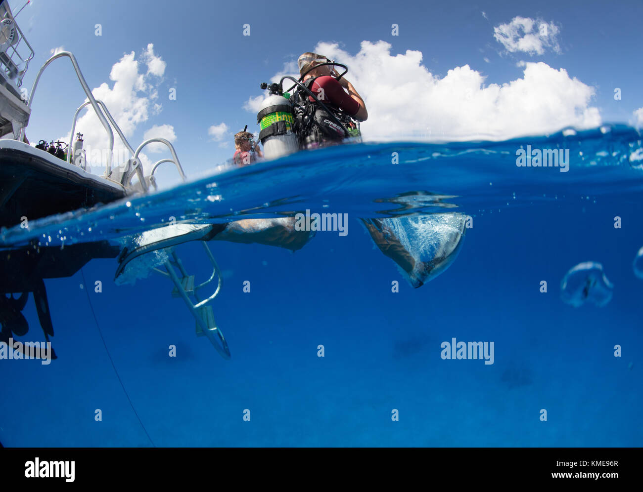 Scuba divers enter water doing giant stride. Stock Photo