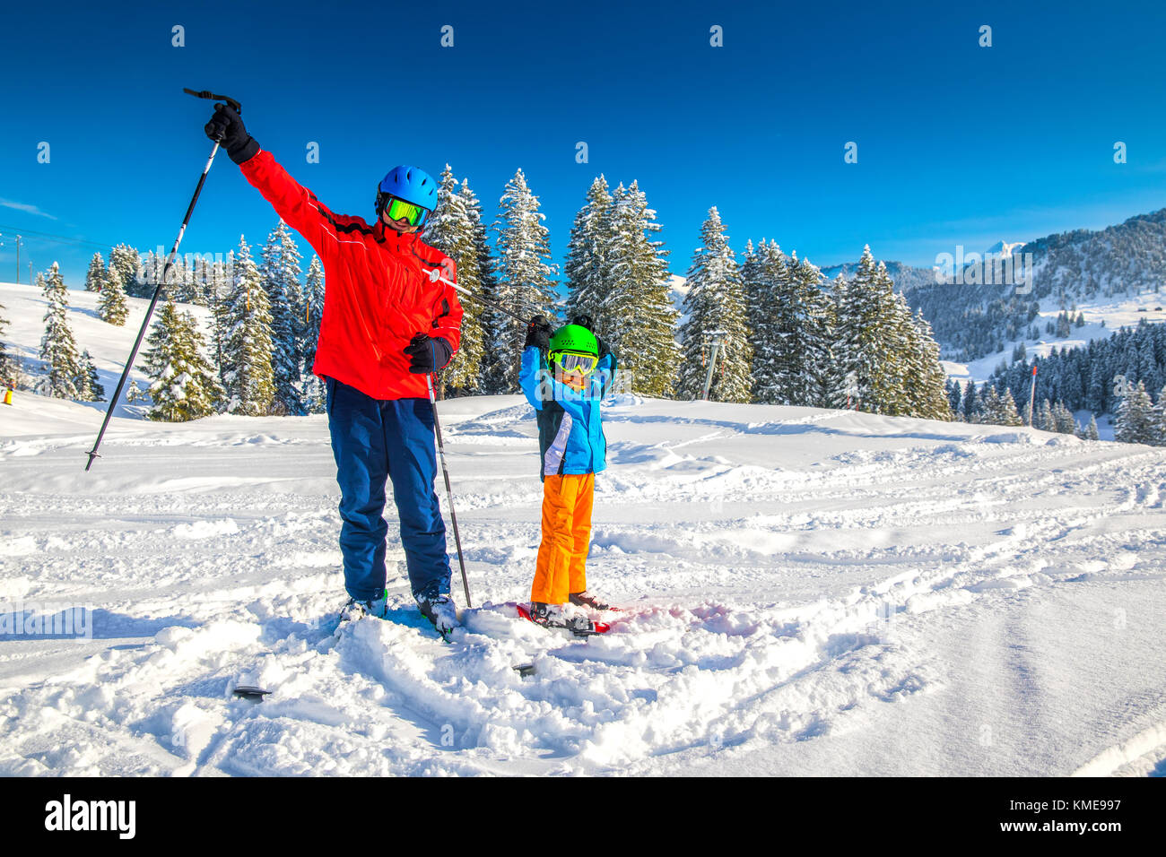 Happy little boy having fun with his father on ski holiday in Alps. Stock Photo