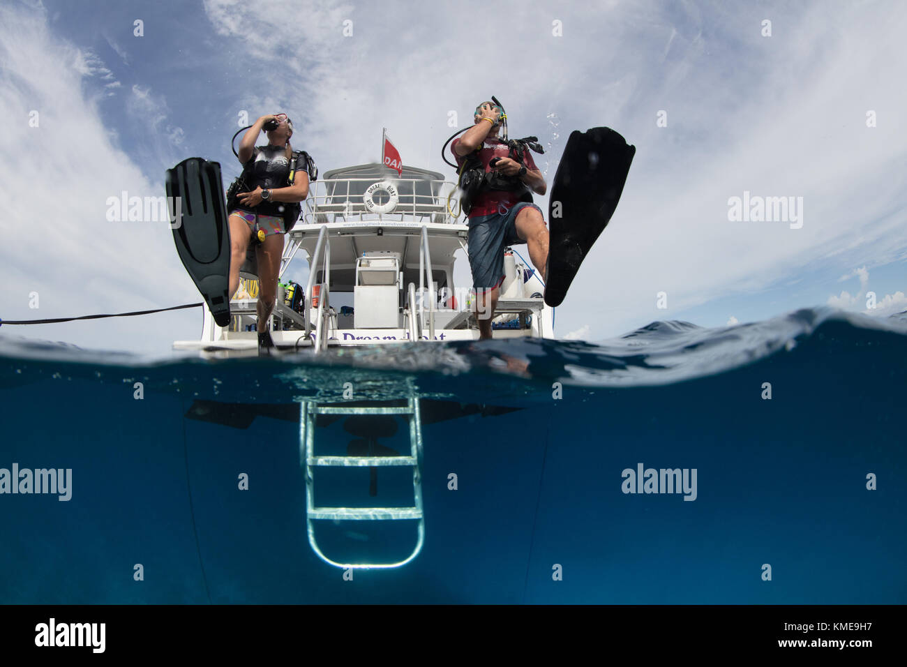 Scuba divers enter water doing giant stride. Stock Photo