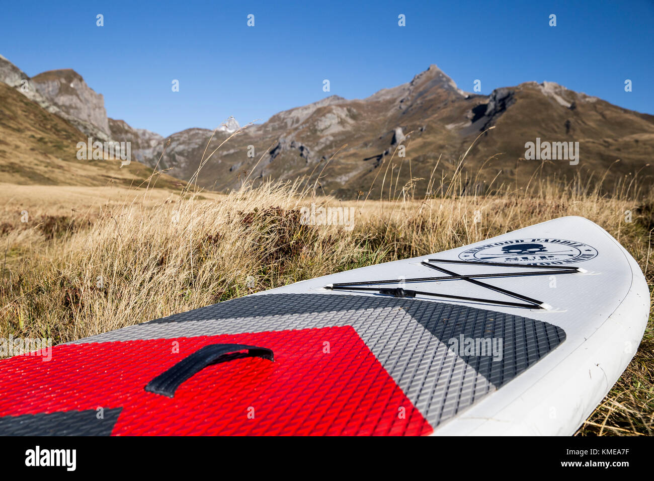 Stand up paddle board lying in meadow and mountains of Italian Alps in background,Little St Bernard Pass,Savoie,France Stock Photo